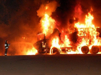 Bombeiro durante combate as chamas que consumiram carreta. (Foto: Acácio Gomes / Nova News)